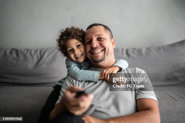 father and son watching tv at home - point of view - children watch tv stockfoto's en -beelden