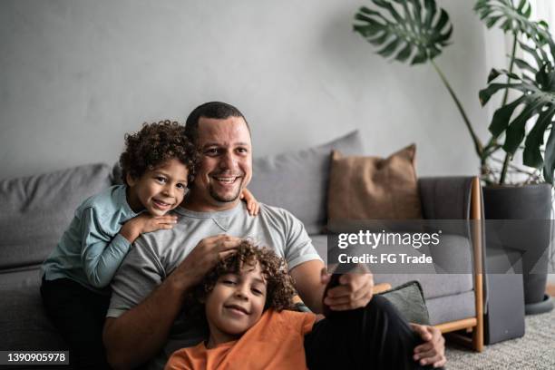 father and sons watching tv at home - a brazil supporter stock pictures, royalty-free photos & images