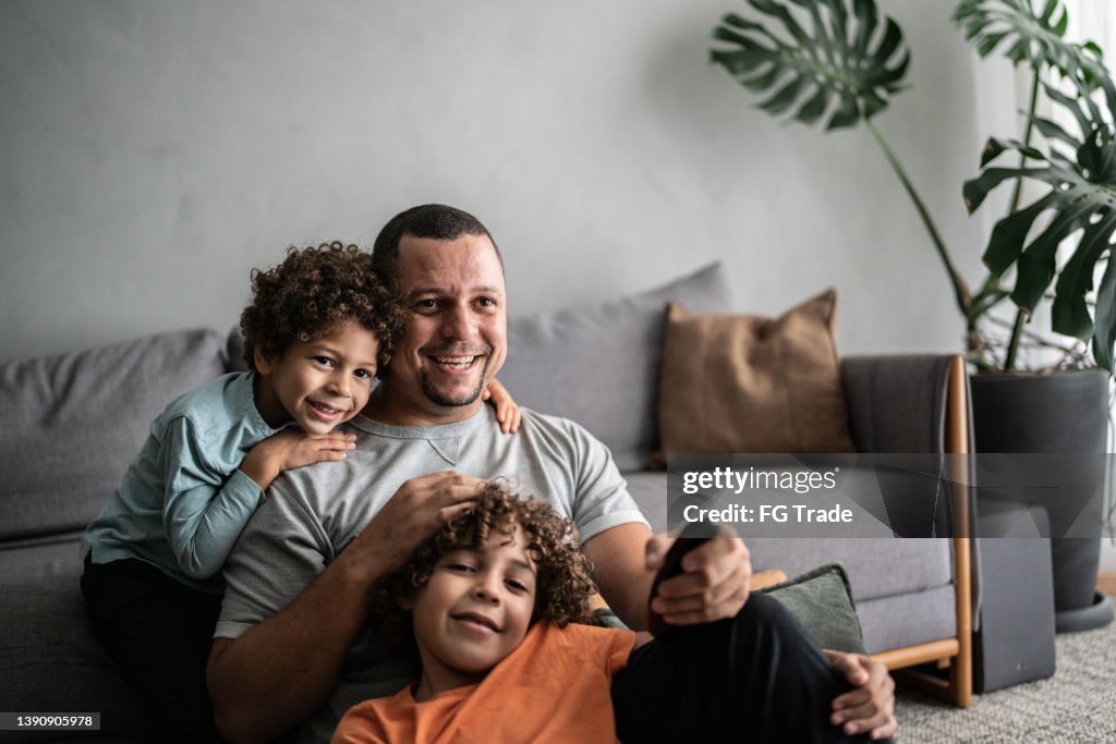 Father and sons watching TV at home