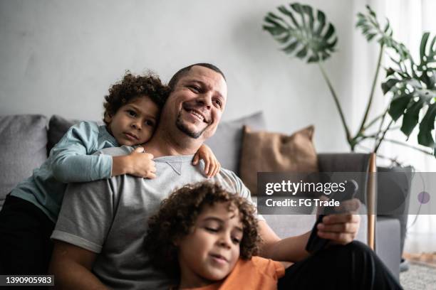 father and sons watching tv at home - family watching television stock pictures, royalty-free photos & images