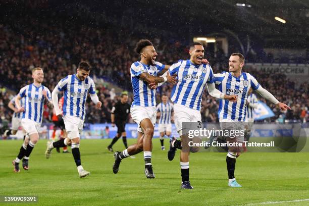 Jon Russell of Huddersfield Town celebrates with team mates Sorba Thomas and Harry Toffolo after scoring their sides first goal during the Sky Bet...