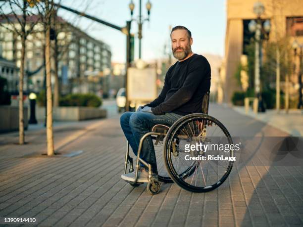 homme handicapé dans une ville - chaise roulante photos et images de collection