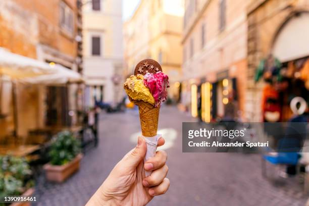 eating ice cream in the streets of rome, personal perspective view - crème glacée photos et images de collection