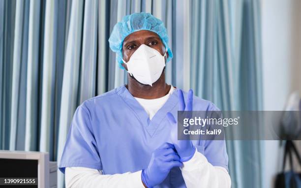 afroamerikanische krankenschwester beim anziehen von op-handschuhen - get dressed male stock-fotos und bilder