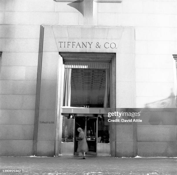 Woman passes the famous Tiffany & Co. Storefront, at 5th Avenue and 57th Street, in 1957 in New York City, New York. Photo taken to illustrate the...