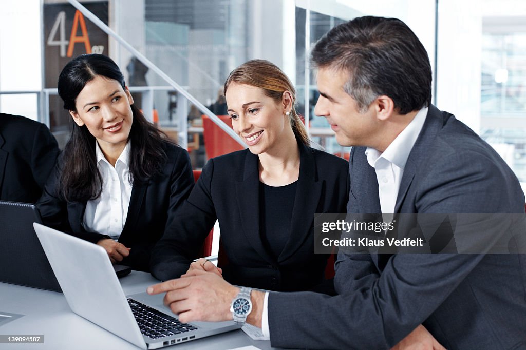 3 businesspeople looking at laptop