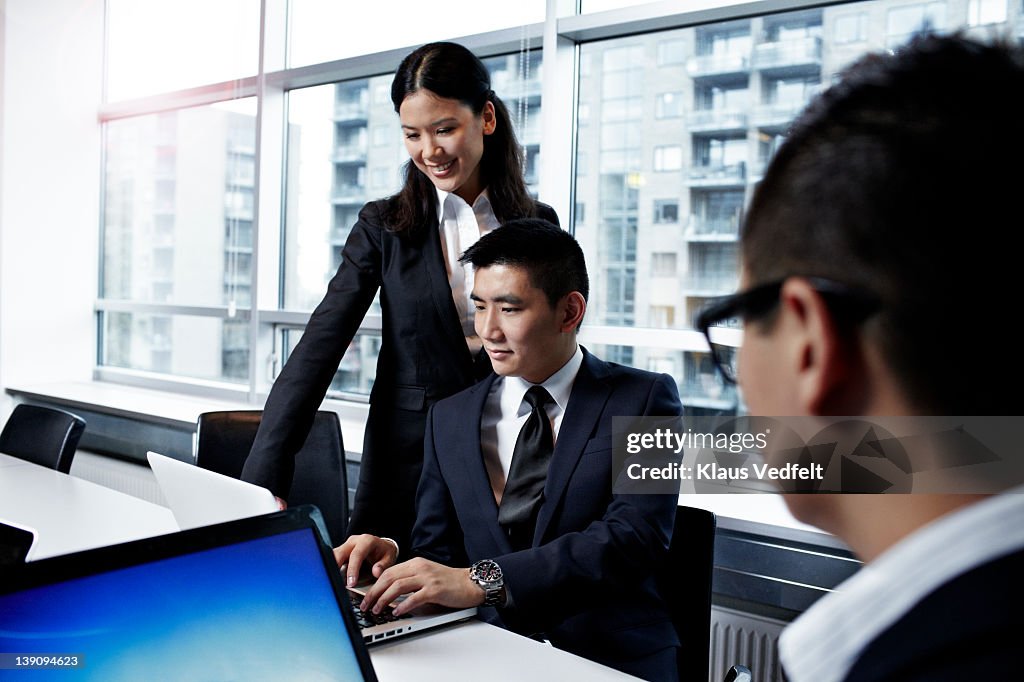 Young asian businesspeople looking at laptop