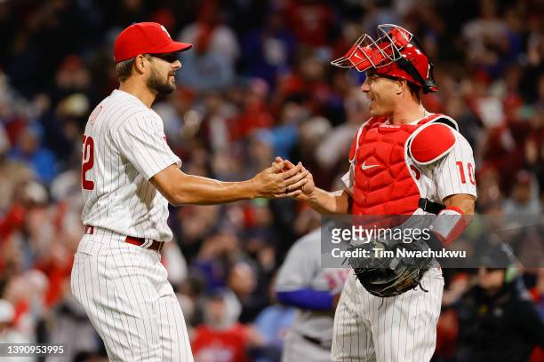Brad Hand and J.T. Realmuto of the Philadelphia Phillies celebrate after defeating the New York Mets at Citizens Bank Park on April 11, 2022 in...