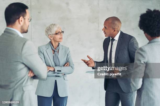 mixed group of business people standing and talking - meeting candid office suit stock pictures, royalty-free photos & images