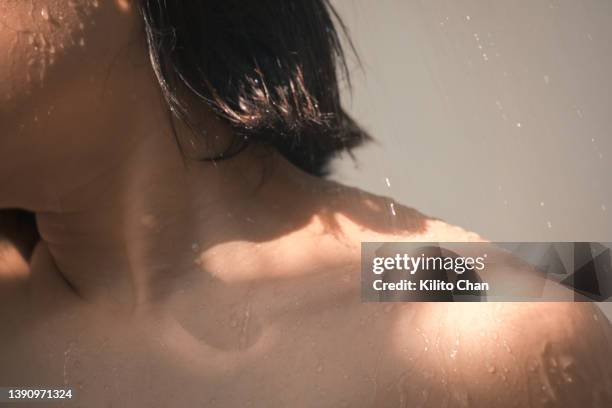 closeup of an asian woman taking a shower - collar bone stock pictures, royalty-free photos & images