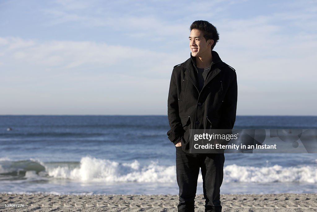 Young man standing on beach on a sunny day