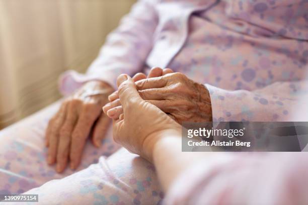 mature woman sitting with her elderly mother at home - pyjamas stock pictures, royalty-free photos & images