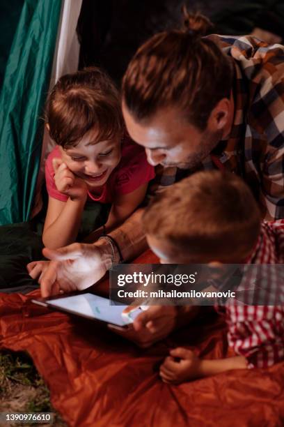 dad showing tablet to kids - brother blanket stockfoto's en -beelden