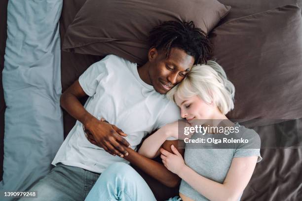 romantic couple, family woman and man lying and sleeping together, relaxing and having nap indoors - romantic young couple sleeping in bed stock pictures, royalty-free photos & images