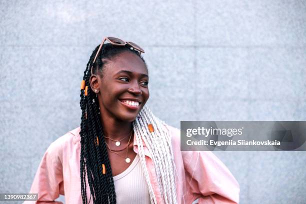 young black braided woman smiling outdoors. - retreat women diverse stockfoto's en -beelden