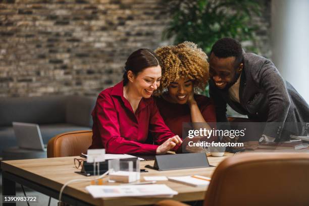 three diverse business colleagues looking at funny memes during coffee break - meme stock stock pictures, royalty-free photos & images