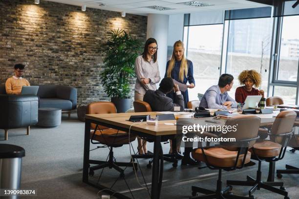 group of diverse young business people having a project briefing in a modern office space - wide shot stock pictures, royalty-free photos & images