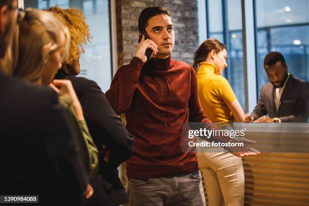 group of people waiting in line behind a front desk in the office lobby - lining up imagens e fotografias de stock