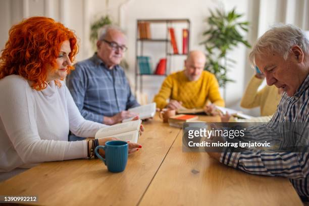 senior caucasian people reading the reference book, during book reading meeting - senior colored hair stock pictures, royalty-free photos & images
