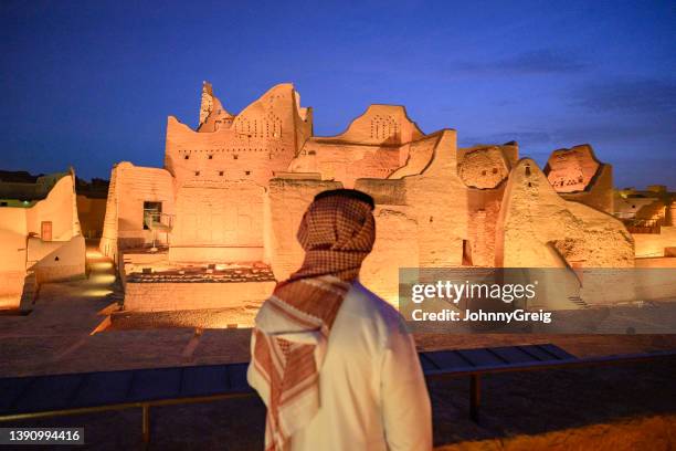 hombre saudí admirando el iluminado palacio salwa en el crepúsculo - arabia saudí fotografías e imágenes de stock