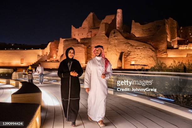 mittleres junges saudisches paar erkundet nachts das freilichtmuseum - saude stock-fotos und bilder
