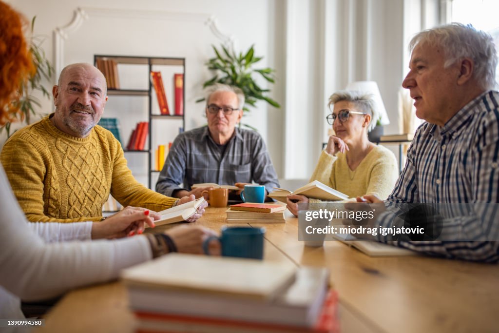 Während des Buchclubtreffens diskutieren neugierige Senioren über das Nachschlagewerk