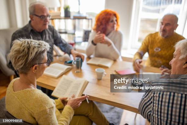 caucasian senior people giving their opinions about book, during book club meeting - book club meeting stock pictures, royalty-free photos & images