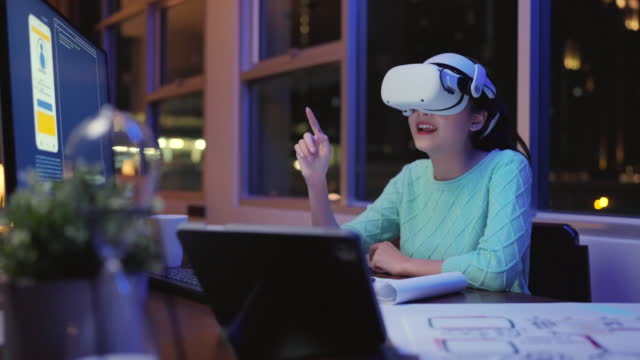 Creative Asian Young female woman wearing smart virtual  glasses and joining business meeting on augmented reality metaverse working space,asia woman using a VR headset to explore virtual space video conference abroad country at night