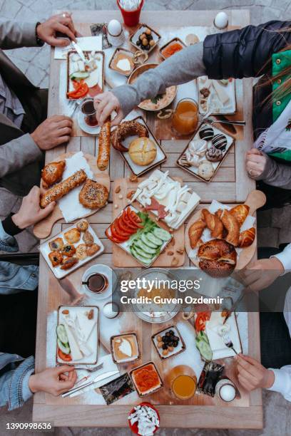 people eating breakfast, people eating, turkish breakfast, sunday big breakfast or brunch with white cheese and egg, turkish spread breakfast served in the restaurant, menemen, orange juices - turkish people stock pictures, royalty-free photos & images