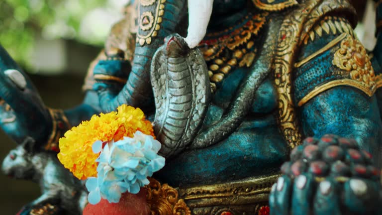 https://media.gettyimages.com/id/1390998771/video/an-old-stone-statue-of-ganesha-covered-with-moss-with-a-wreath-of-yellow-flowers-on-his-neck.jpg?b=1&s=640x640&k=20&c=4mN5YWyCw9XllN-Pr5iA_5WK4lEeAI8fHBTtheEc5tI=