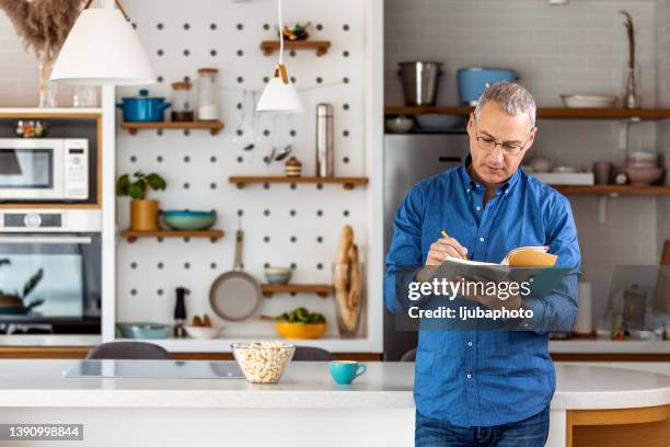 businessman taking notes in diary - freelance work candid stock pictures, royalty-free photos & images