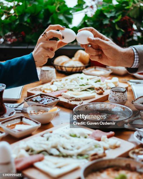 eier zusammenschlagen, zwei leute haben einen eierwettbewerb, eier knacken, indem sie sich gegenseitig schlagen, eier zum frühstück essen - brunch stock-fotos und bilder