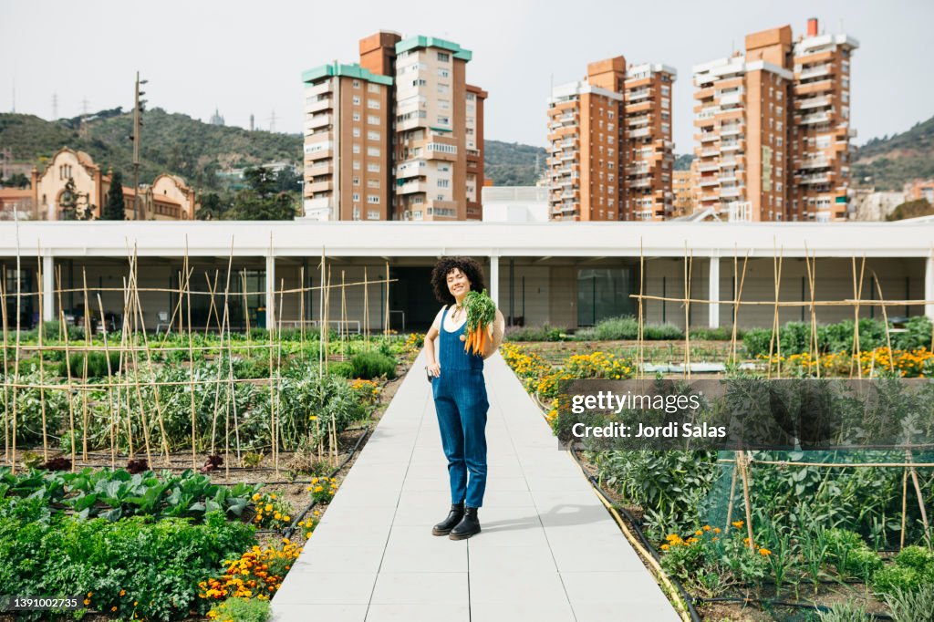 Woman holding a bunch of carrots in a garden