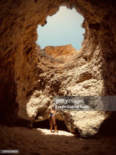 side view of man inside cave in portimao - distrito de faro portugal fotografías e imágenes de stock