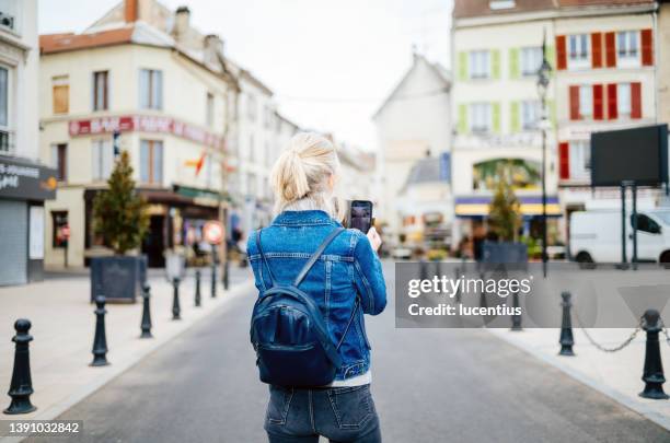 mature female tourist in the village of la ferte sous jouarre in france. - central europe stock pictures, royalty-free photos & images