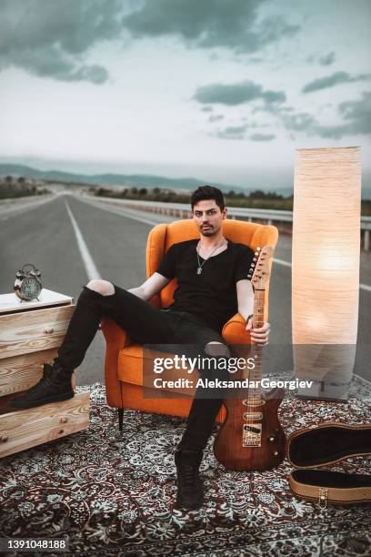 hombre barbudo que lleva la sala de estar y la guitarra a la carretera - guitar case fotografías e imágenes de stock