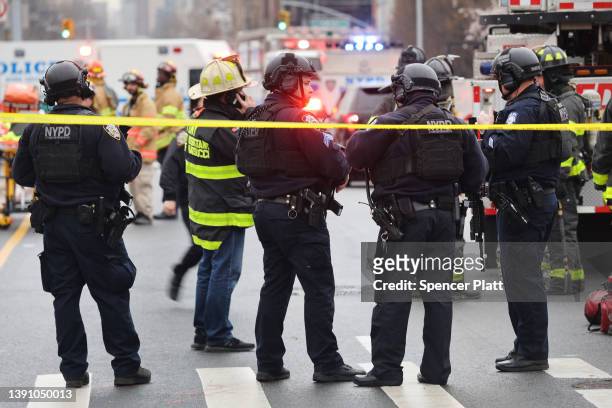 Police and emergency responders gather at the site of a reported shooting of multiple people outside of the 36 St subway station on April 12, 2022 in...