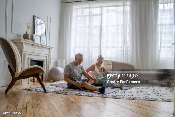 senior couple working out at home - couple yoga indoors stock pictures, royalty-free photos & images