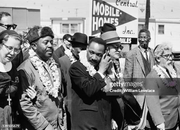 African-American civil rights activist Martin Luther King Jr listening to a transistor radio in the front line of the third march from Selma to...