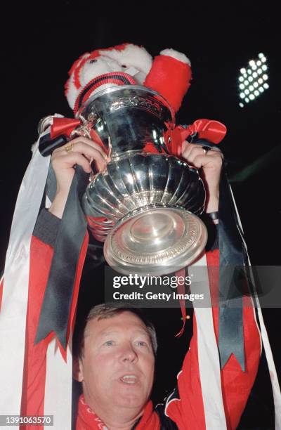 Manchester United manager Sir Alex Ferguson holds aloft the trophy after 1990 FA Cup Final replay victory against Crystal Palace at Wembley Stadium...