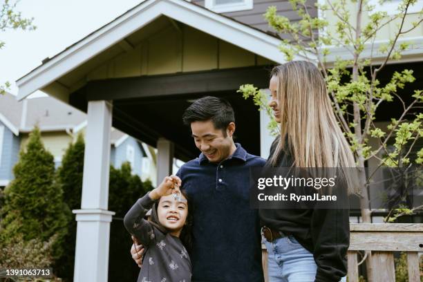 multi-ethnic family holding keys to new home - homeowner stockfoto's en -beelden