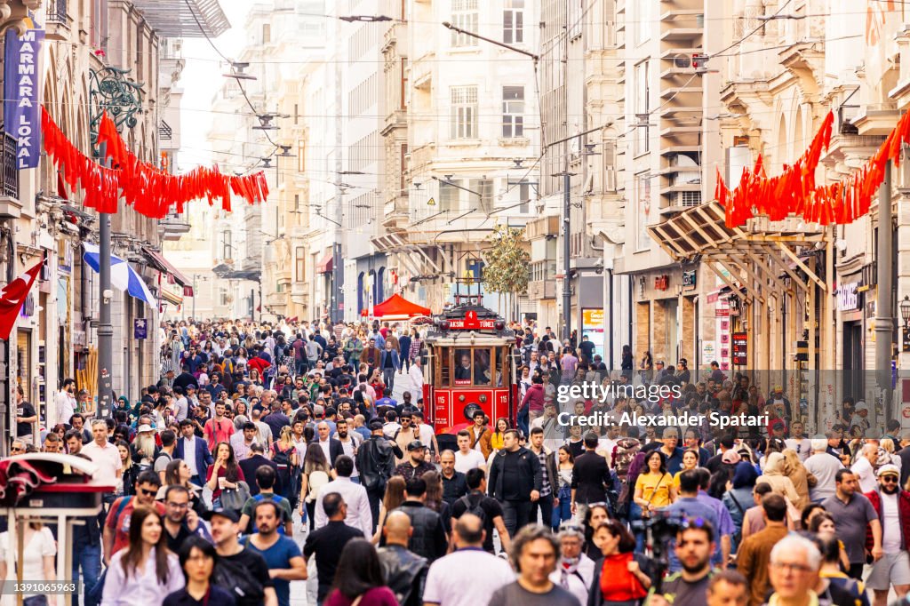 Istiklal avenue with crowds of people and an old red cable car, Turkey, Istanbul