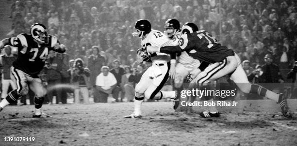 Los Angeles Rams Cody Jones and Merlin Olsen attempt to tackle a scrambling Pittsburgh Steelers QB Terry Bradshaw during game action of Los Angeles...