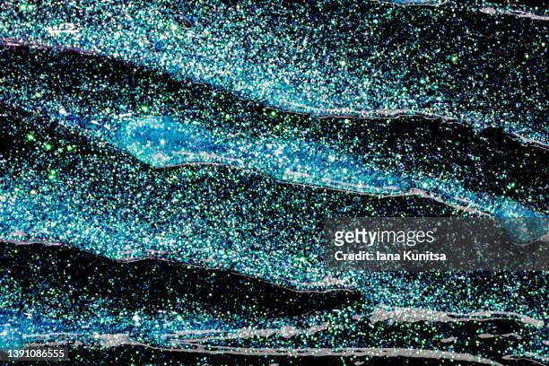 blue glitter gel is smeared on black background. pattern. - eyeshadow foto e immagini stock