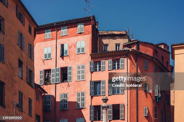 orange tones painted old traditional buildings with jalousie windows against blue sky - grasse imagens e fotografias de stock