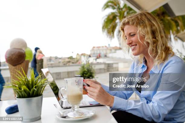 mujer trabajando desde una terraza de playa, en una reunión de zoom de teléfono inteligente, - descontrair fotografías e imágenes de stock