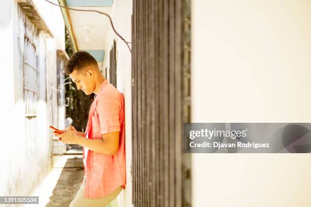 young latin man using a mobile phone - honduras people stock pictures, royalty-free photos & images