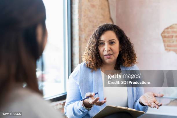 un manager adulte pose une question méconnaissable à une femme lors d’une entrevue - femme question photos et images de collection