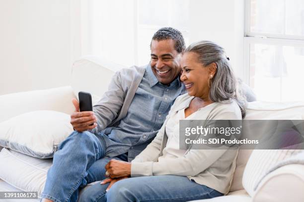 elderly couple have a video call with their daughter - friends laughing at iphone video stock pictures, royalty-free photos & images