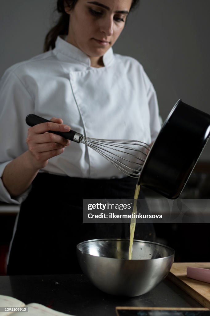 Female confectioner preparing chocolate sauce